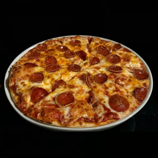 A whole pepperoni pizza, sliced into eight pieces, on a white plate against a dark background.