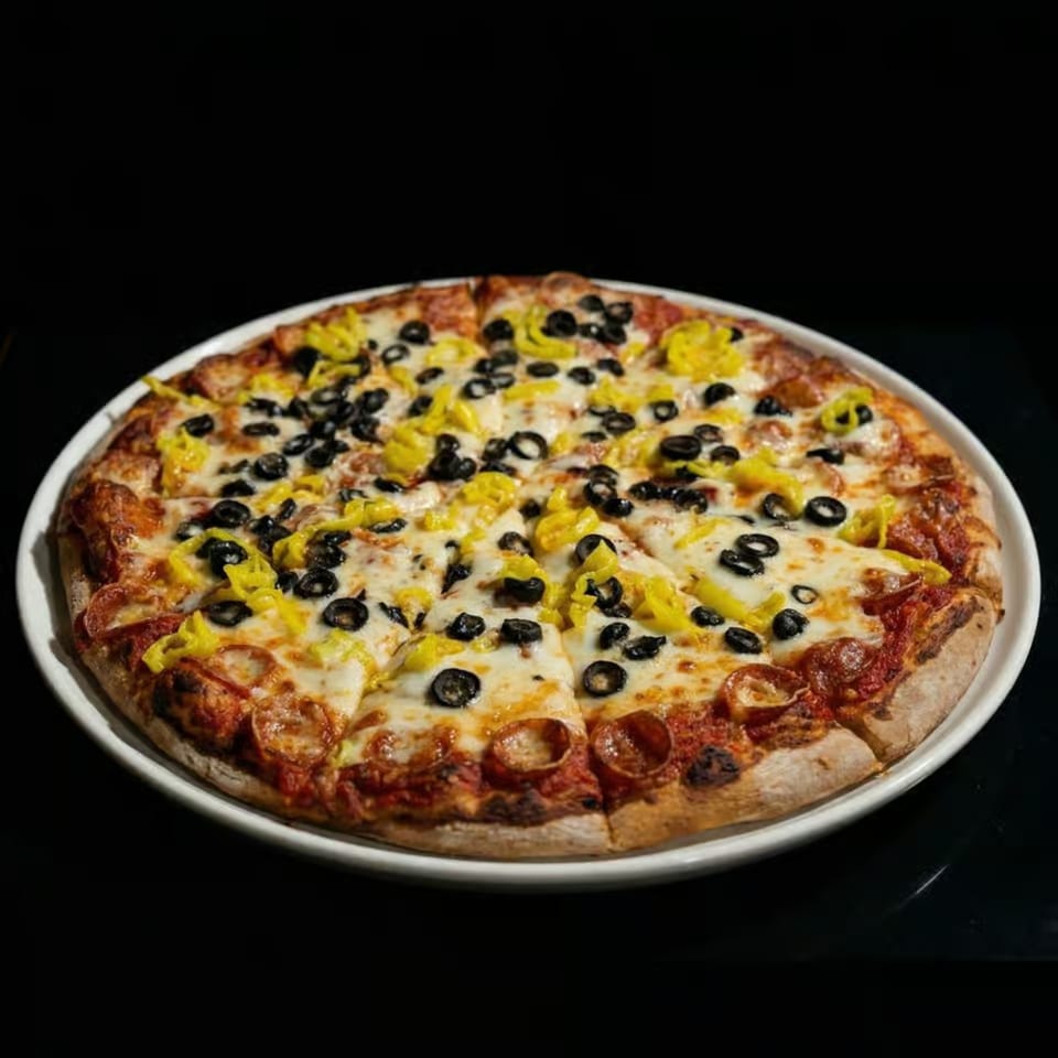 Pepperoni pizza with black olives and banana peppers on a white plate against a dark background.